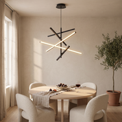 Nikandros Nordic linear chandelier in matte black lit above a round pale oak dining table in a warm lime plaster dining room