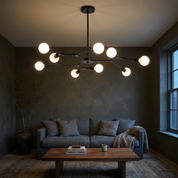 Berenika nine-light sputnik chandelier in black lit in a dark olive limewash sitting room at dusk