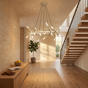 Elpis 20-light sputnik chandelier in gold lit in a bright travertine and oak double-height entrance hall