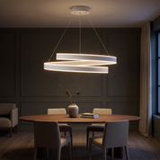 Andromache white spiral ribbon LED ring chandelier lit over a walnut dining table in a dark olive panelled dining room