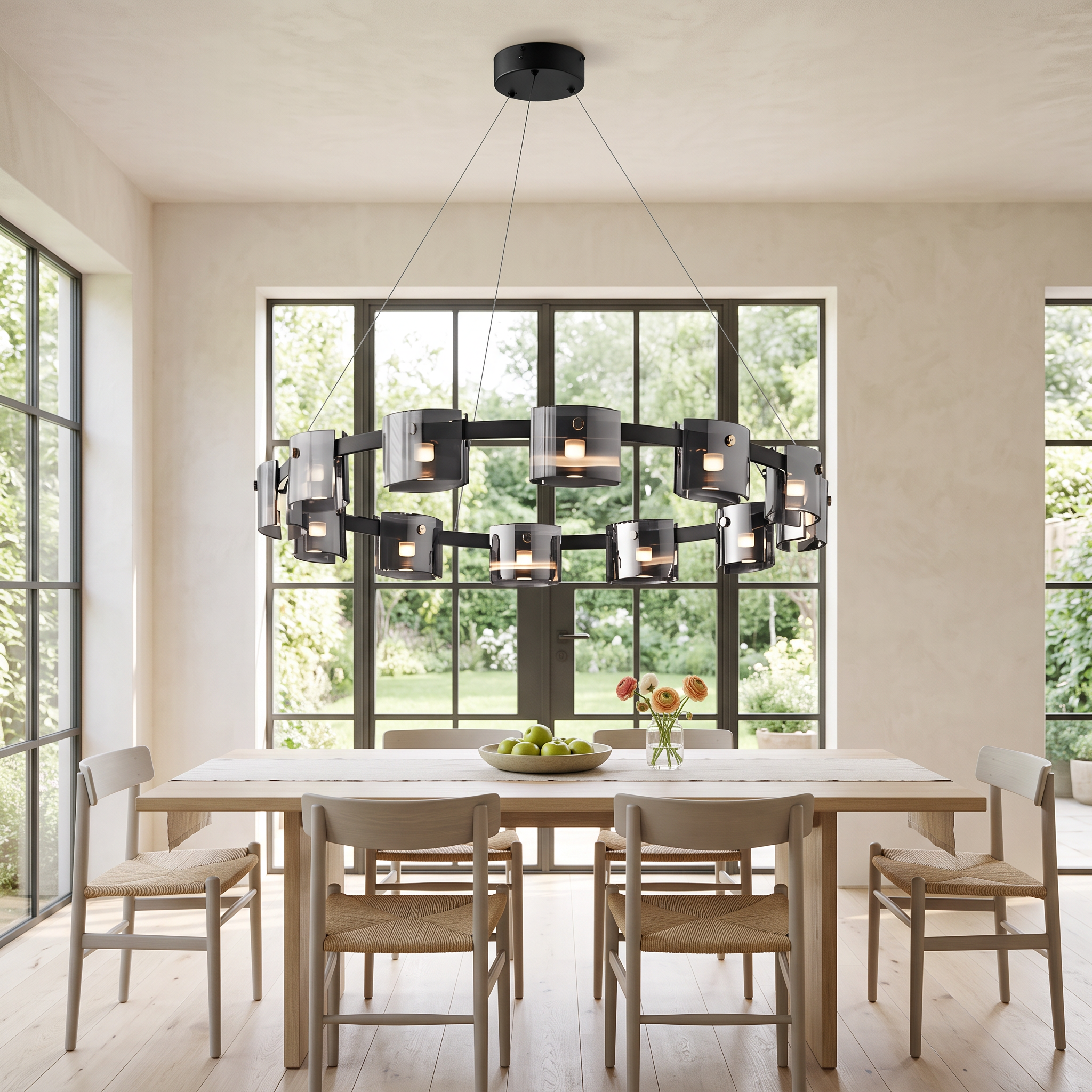 Diokles black ring chandelier with smoked glass cylinders over an oak table in a bright garden-side dining room