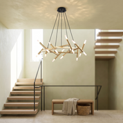 Elpis twenty-light gold crossed-baton chandelier in a bright double-height oak stair hall
