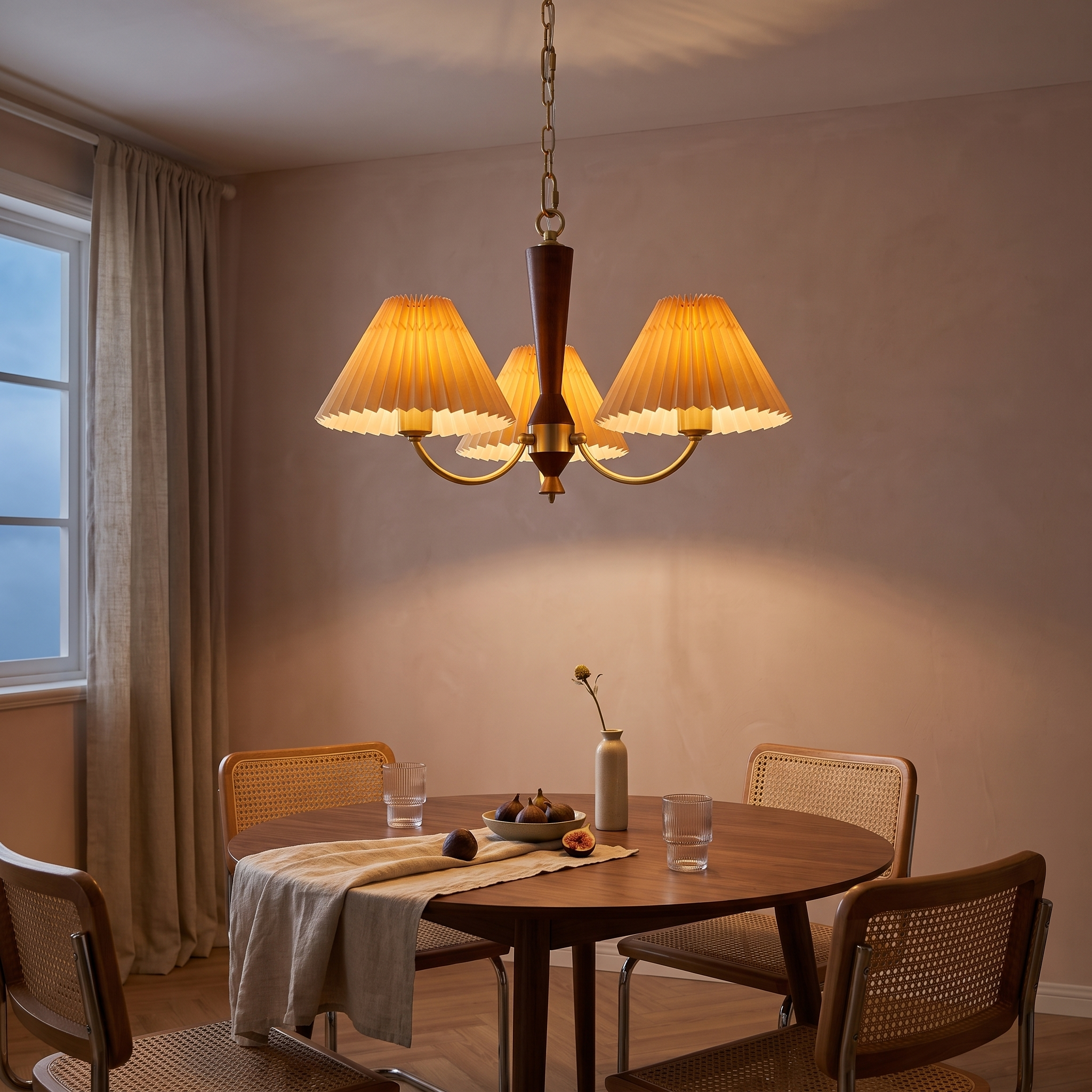 Baukis Pleated Shade Copper and Walnut Chandelier lit over a round walnut table in a clay-plaster dining room