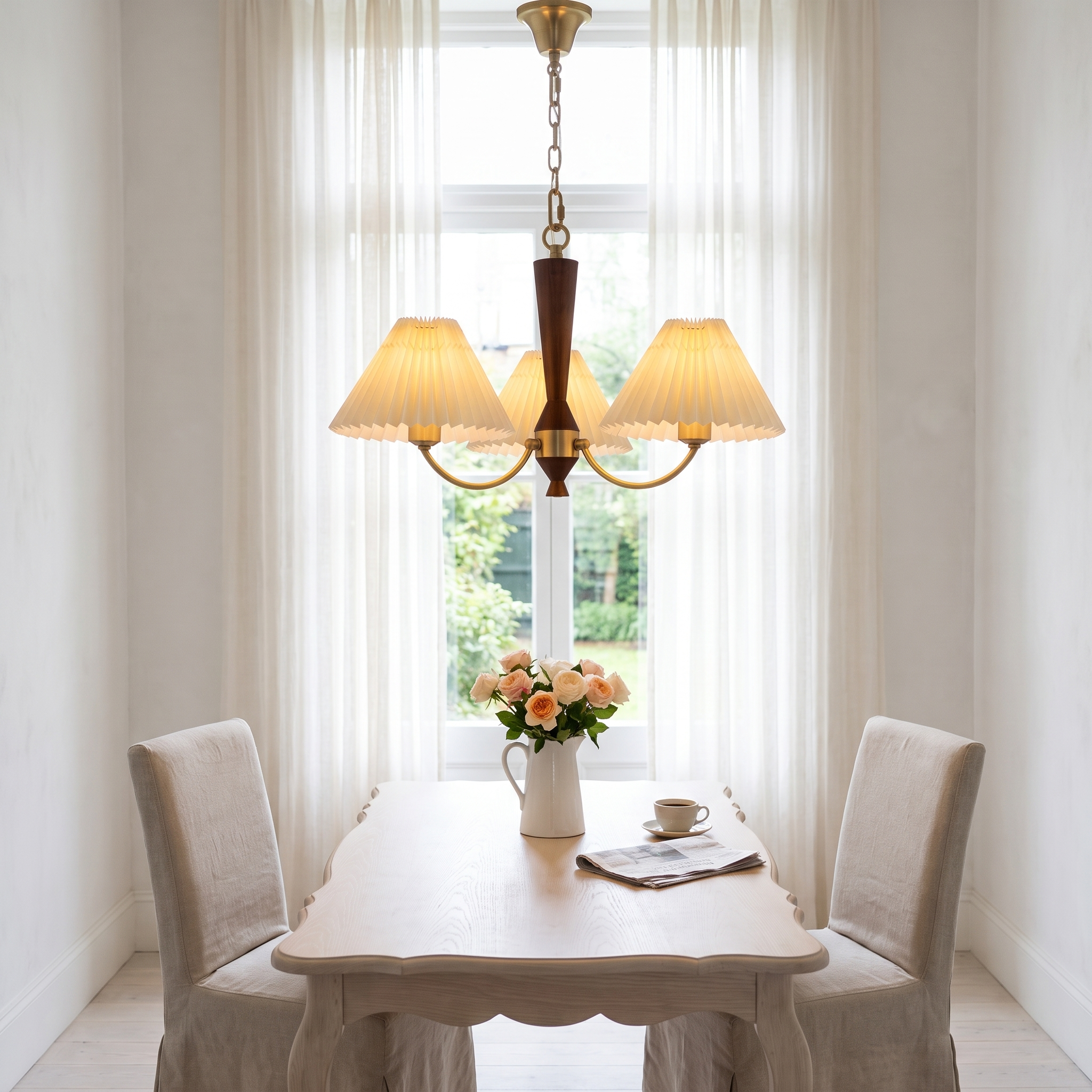 Baukis Pleated Shade Copper and Walnut Chandelier above a pale table in a bright white breakfast room