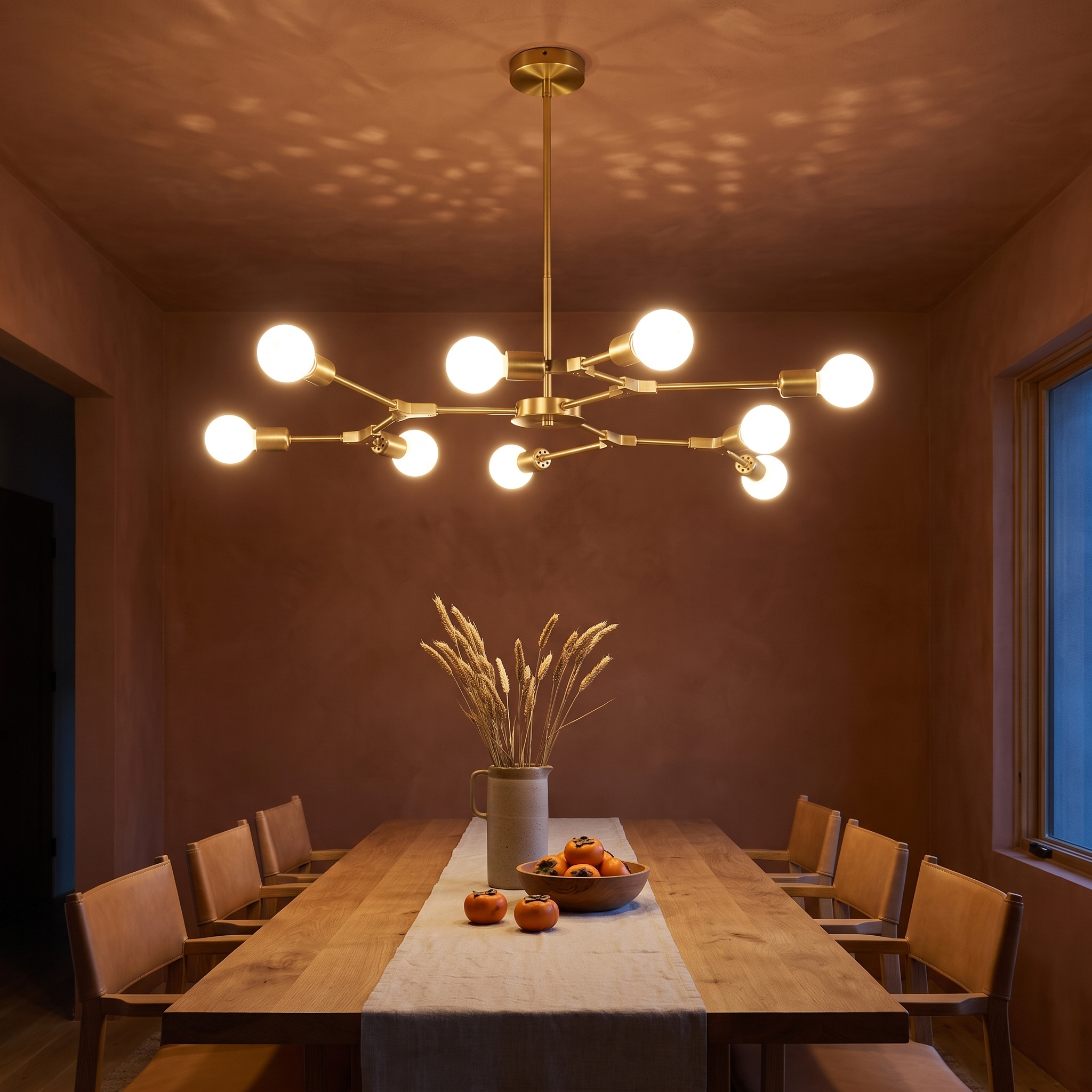 Berenika Nine-Light Sputnik Metal Chandelier in brass lit above an oak table in a terracotta plaster dining room
