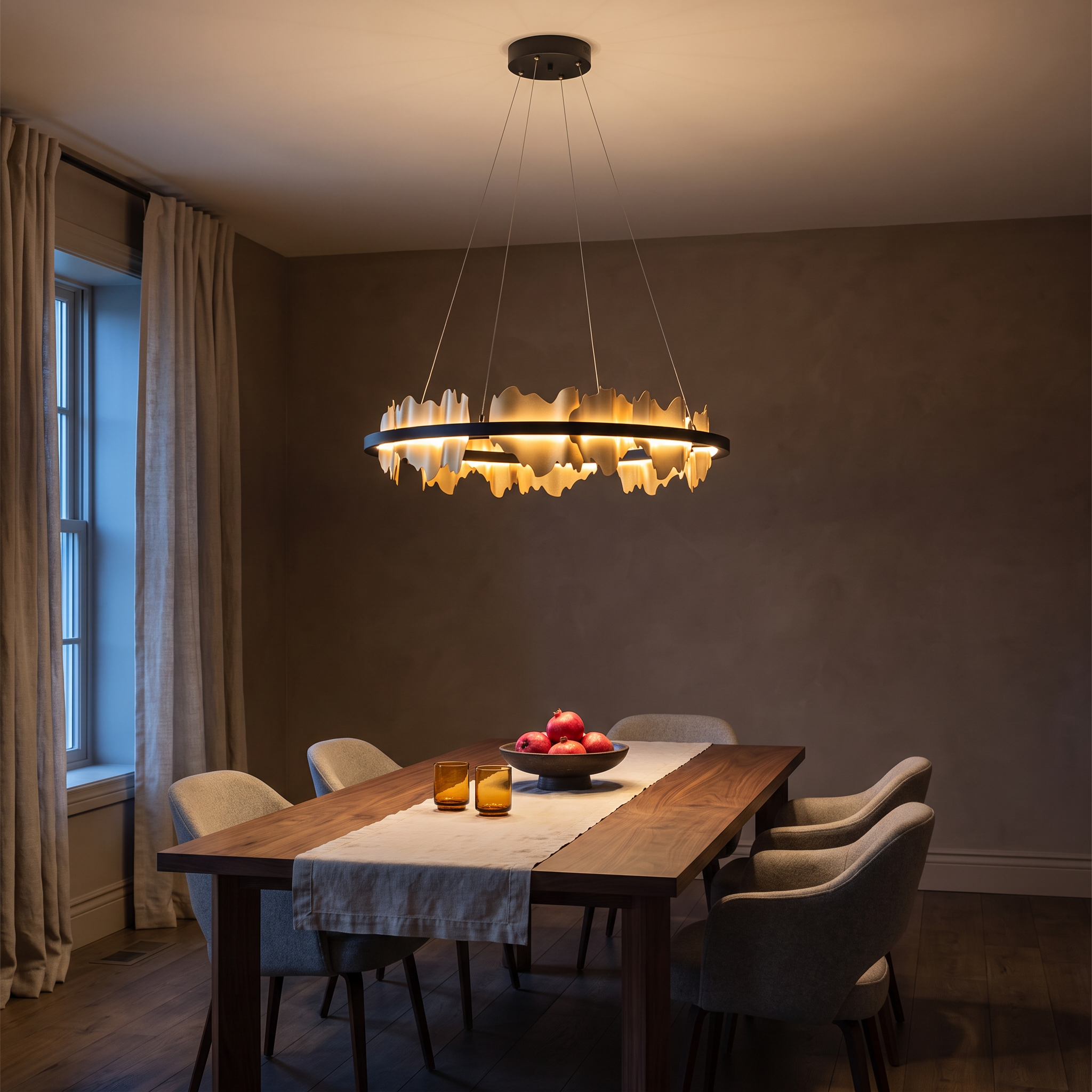 Danae Metal Leaf Round Chandelier in gold lit above a walnut table in a dark plaster dining room