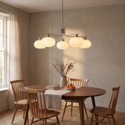 Deinias Five-Light Glass LED Chandelier lit above a walnut table in a warm mid-century dining room