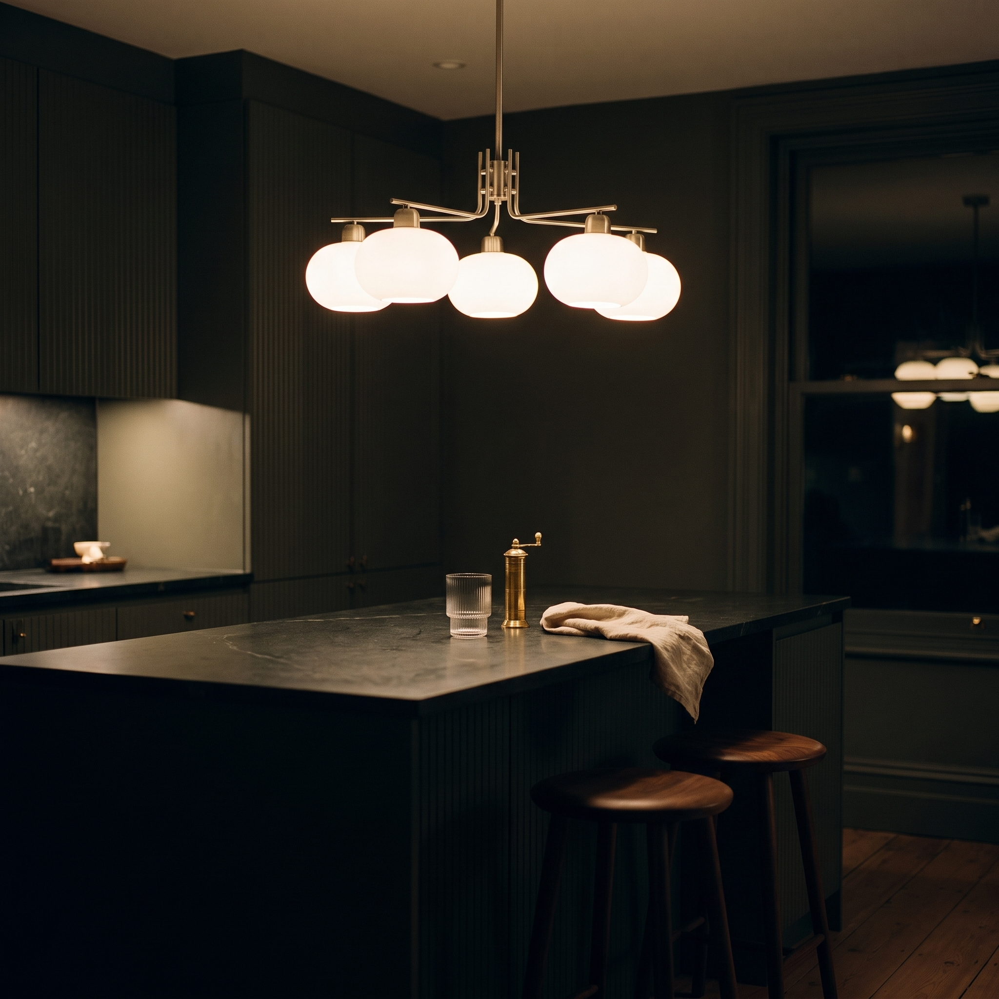 Deinias Five-Light Glass LED Chandelier over an island in a dark charcoal-green evening kitchen