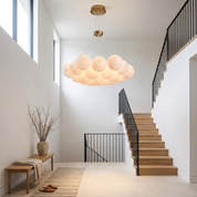 Chrysippos Cascading Globe Cluster Chandelier in a bright double-height stair hall with oak staircase