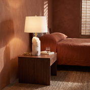 Hestia alabaster table lamp on a walnut nightstand in a terracotta bedroom