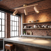 Pyrrhos brass and wood track light with three adjustable heads over a concrete counter in an industrial loft kitchen