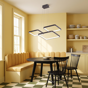 Hermokrates charcoal LED square chandelier lit over a black table in a butter-yellow breakfast room
