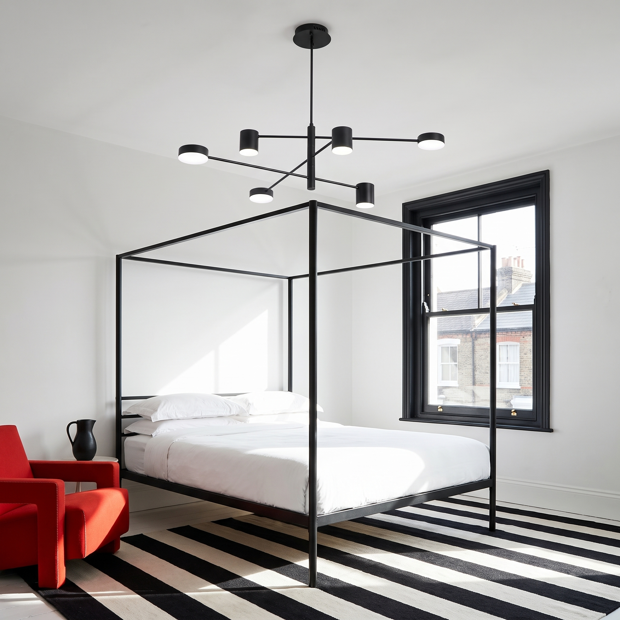 Doriskos black sputnik LED chandelier in a graphic black and white bedroom in morning light
