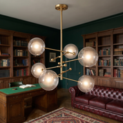 Hegesias geometric globe glass chandelier in brass in a dark-academia study