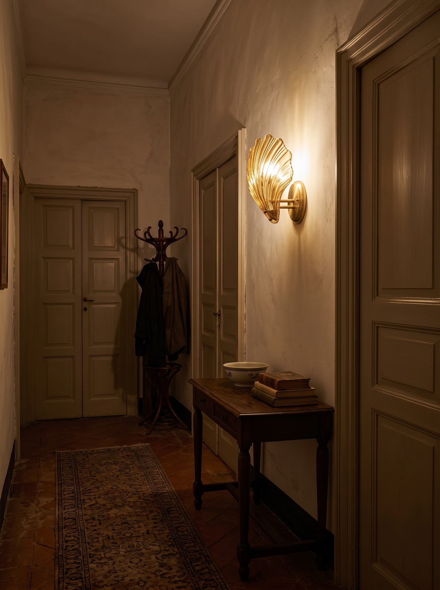 Halia amber glass wall light at night in a furnished hallway