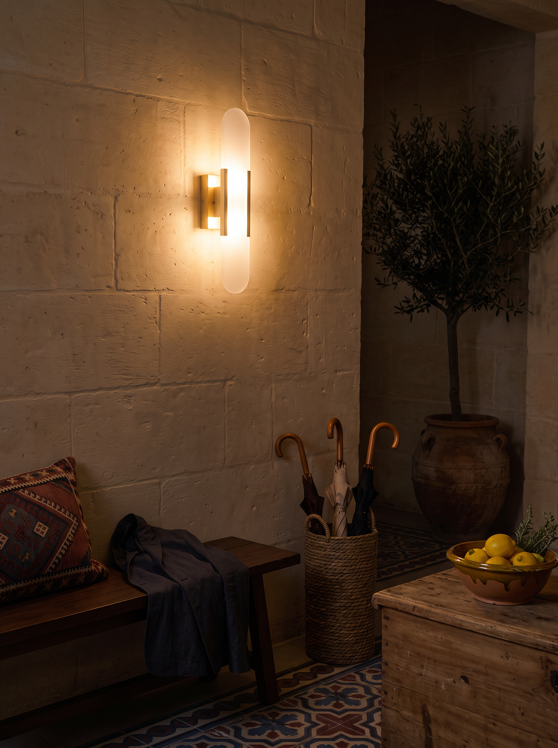 Prymno alabaster wall sconce at night in a furnished entry hall