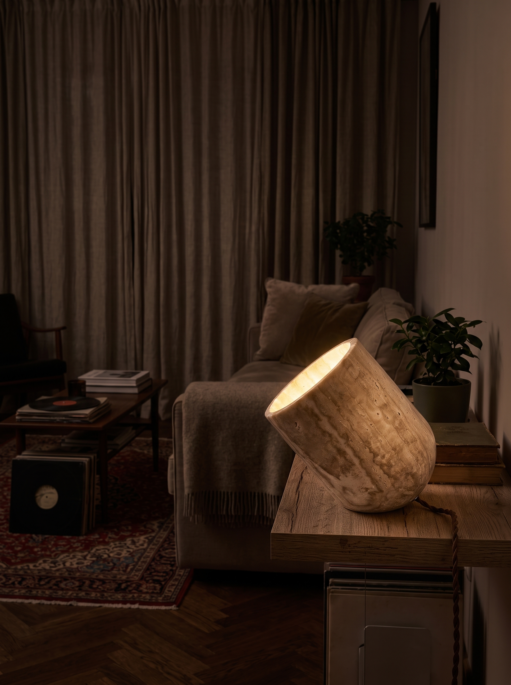 Heliodora travertine table lamp at night in a furnished living room