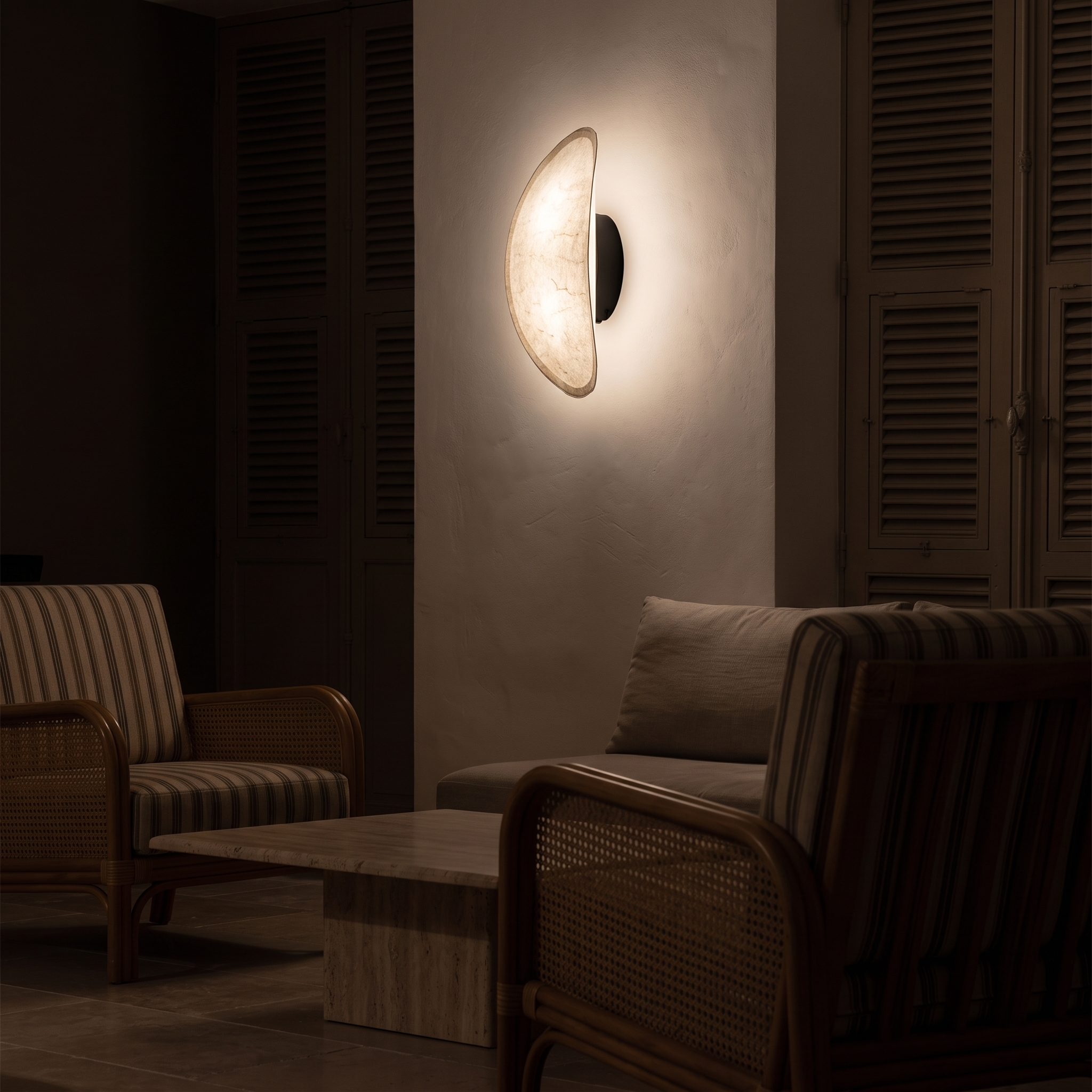 Ananke Cloudlike Paper and Metal Wall Lamp lit at night in an Antibes Riviera apartment living room