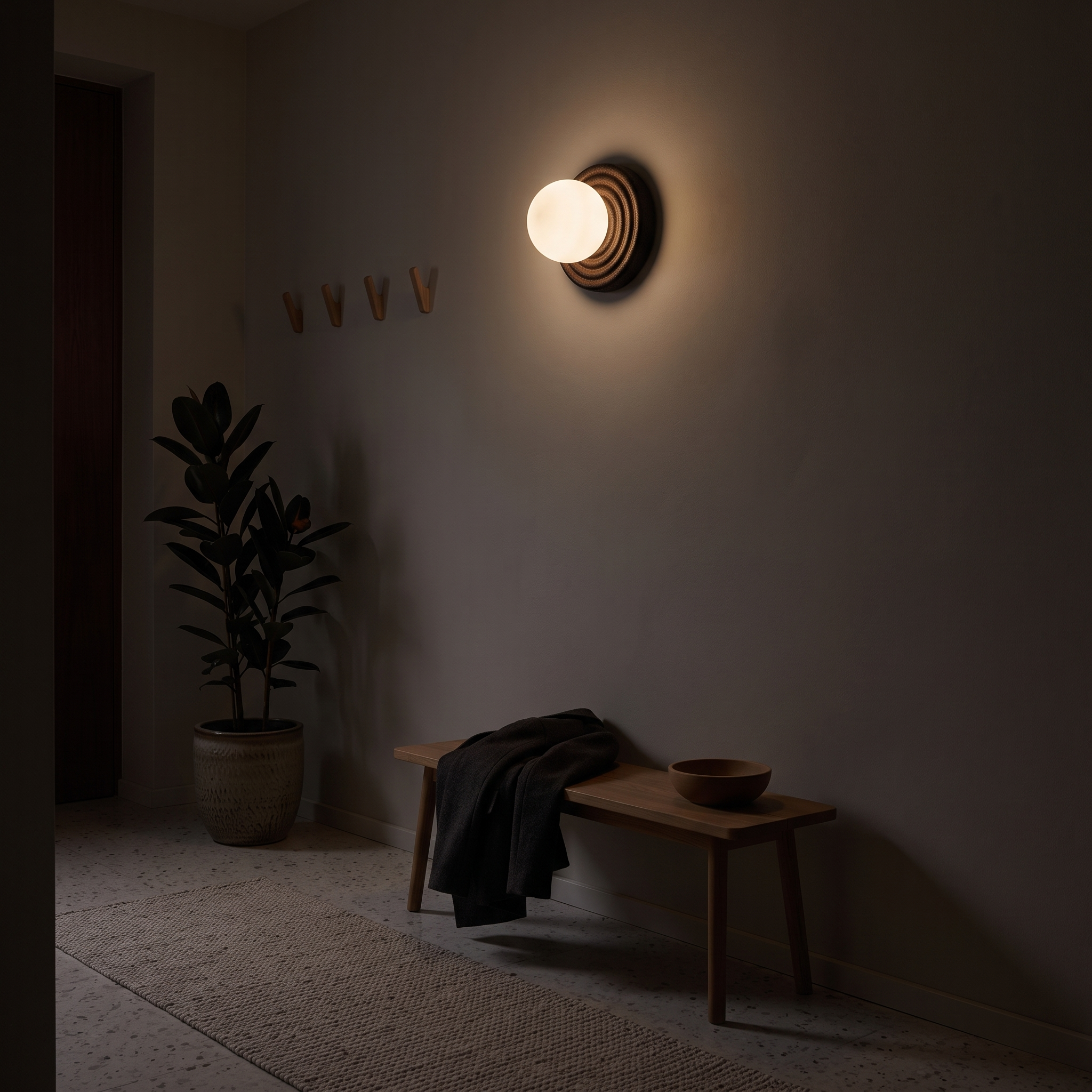 Eurybia Concentric Travertine Ring Sconce lit at night in a Ljubljana riverside apartment hallway