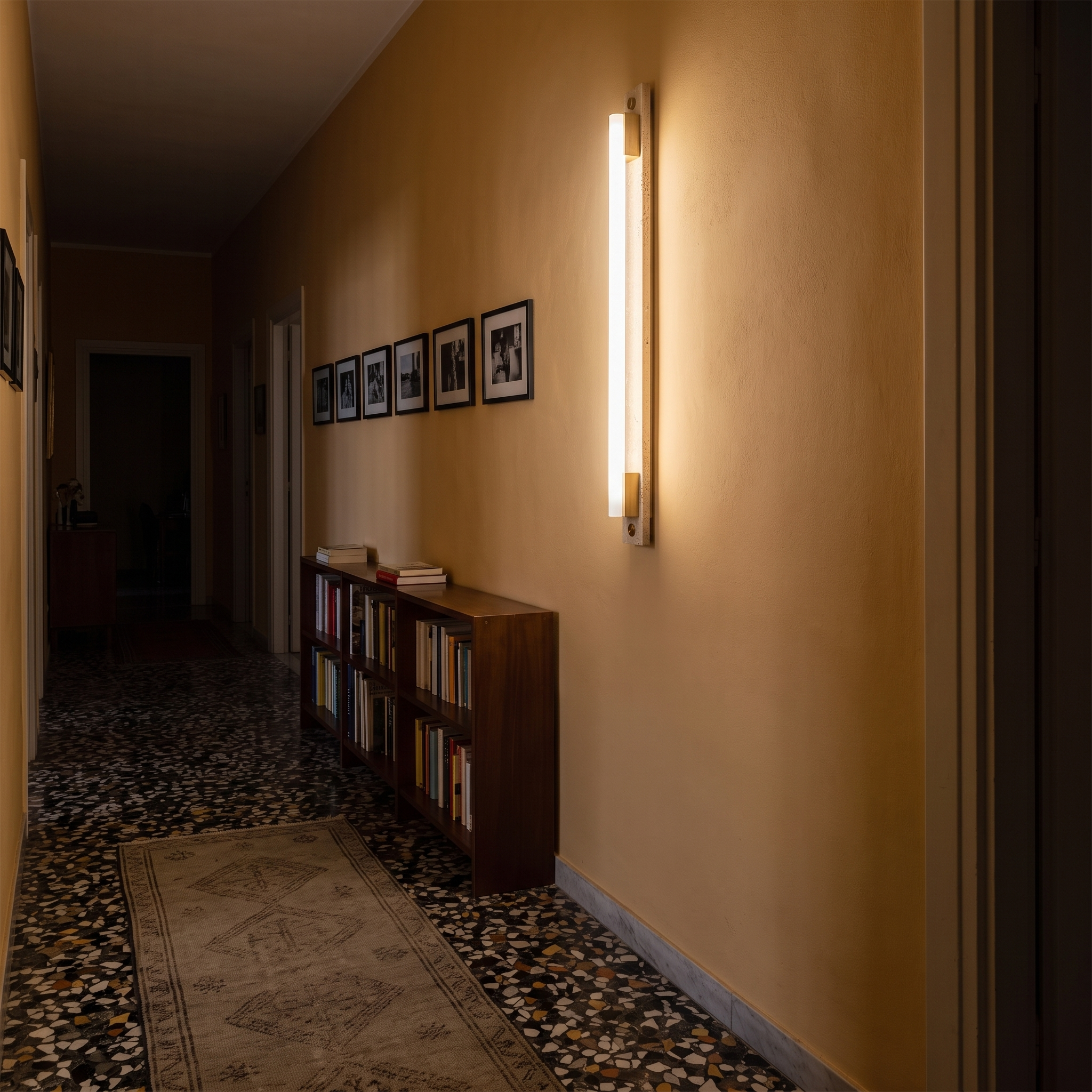 Krios Travertine and LED Tube Wall Bar lit at night in a Rome Testaccio apartment corridor