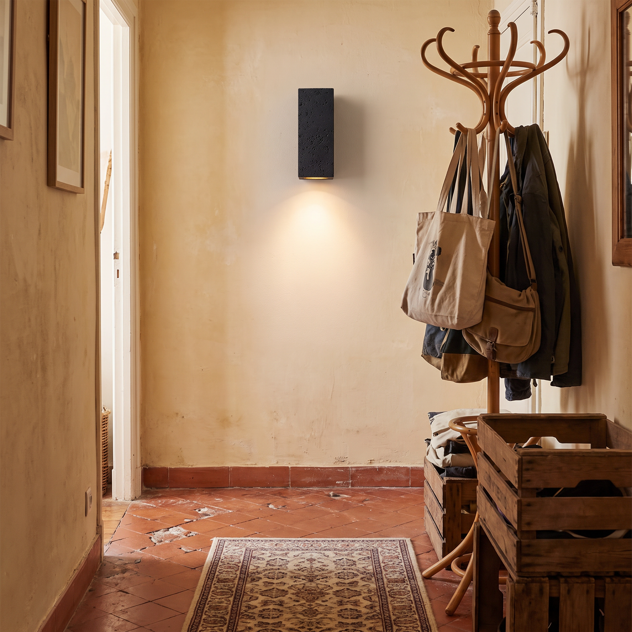 Ophion Black Travertine Block Wall Lamp shown close in a Marseille Panier apartment hallway