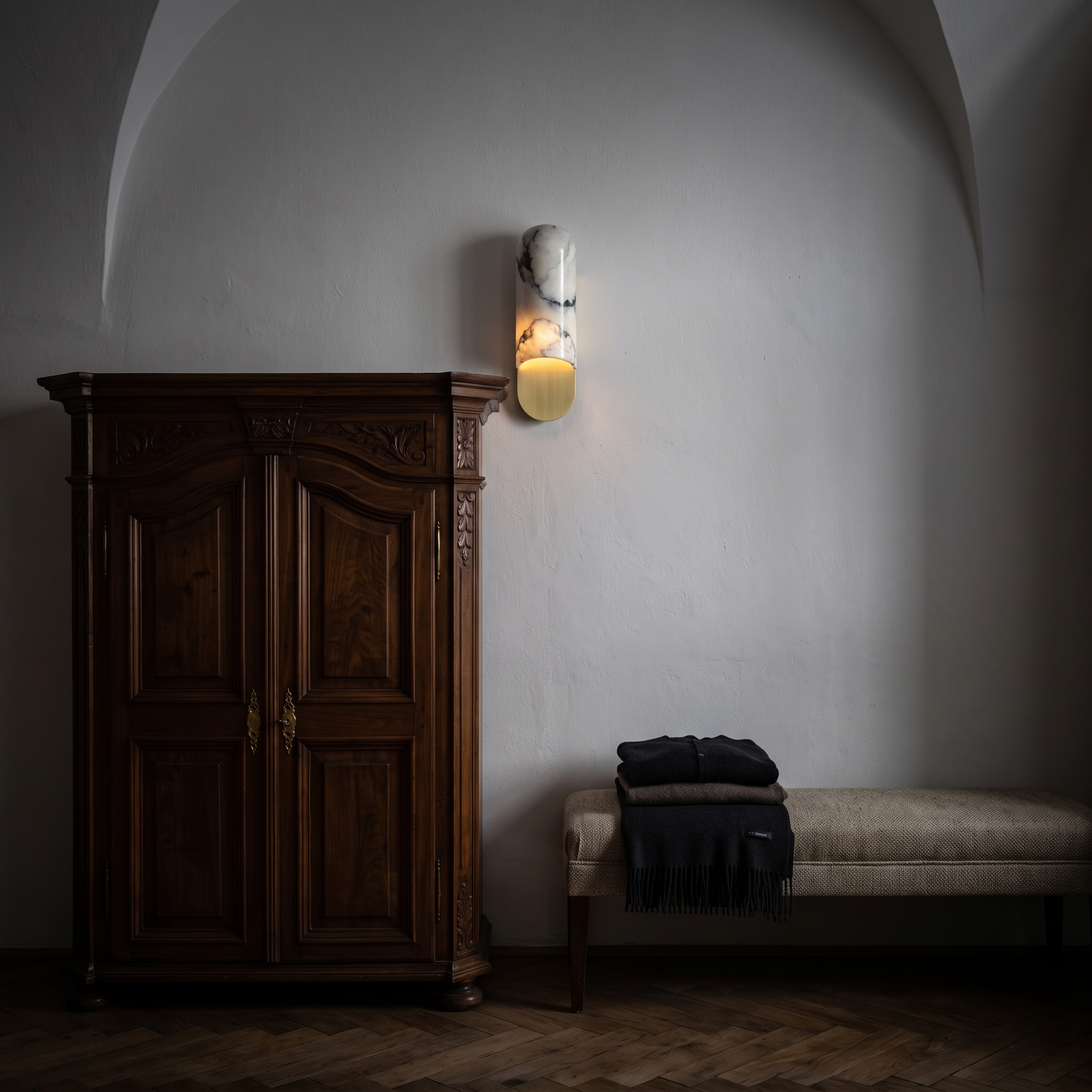 Niobe White Marble and Metal Wall Sconce lit at night in a Salzburg old town apartment dressing area
