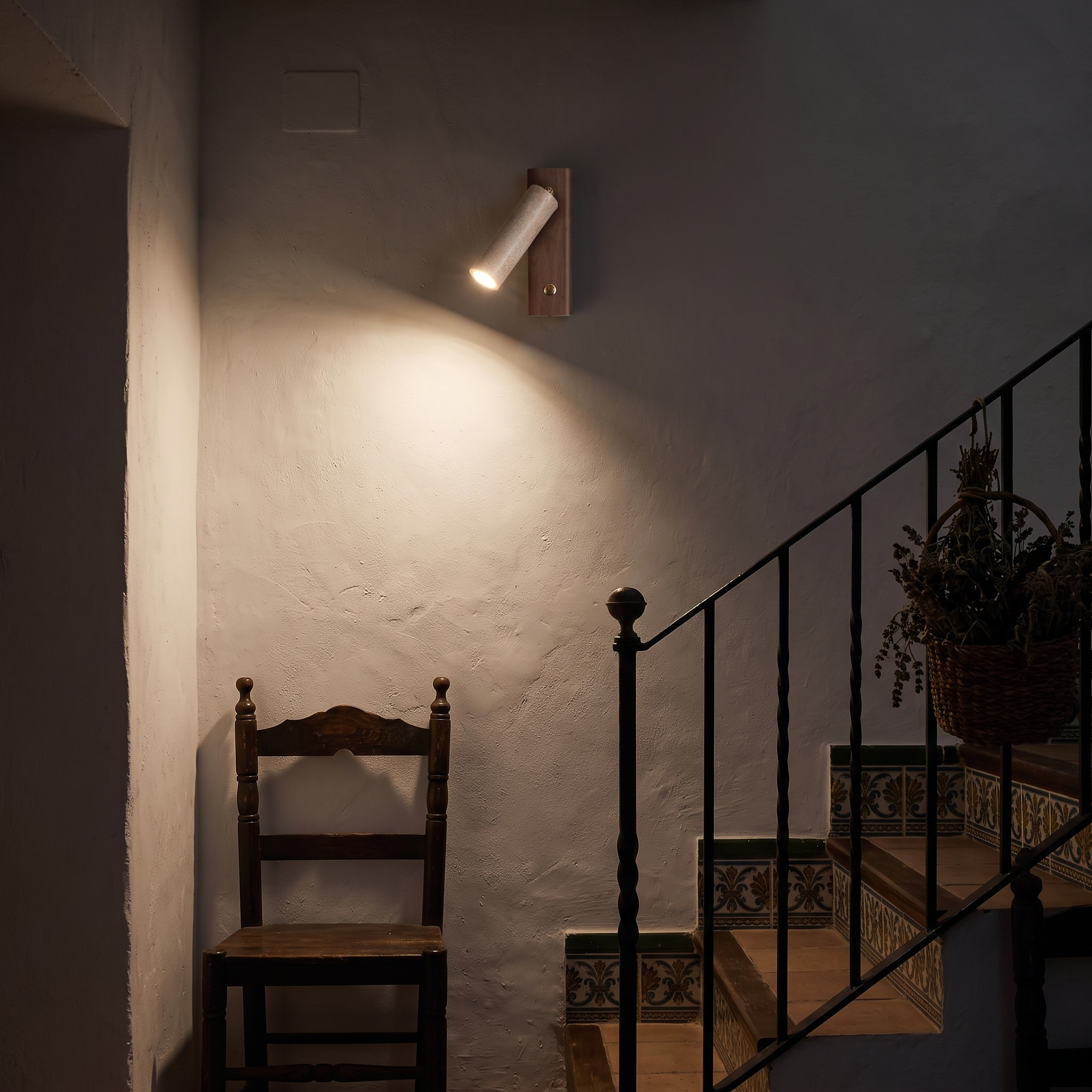 Orpheus Travertine Torch Wall Lamp lit at night in a Ronda Andalusian house stairwell