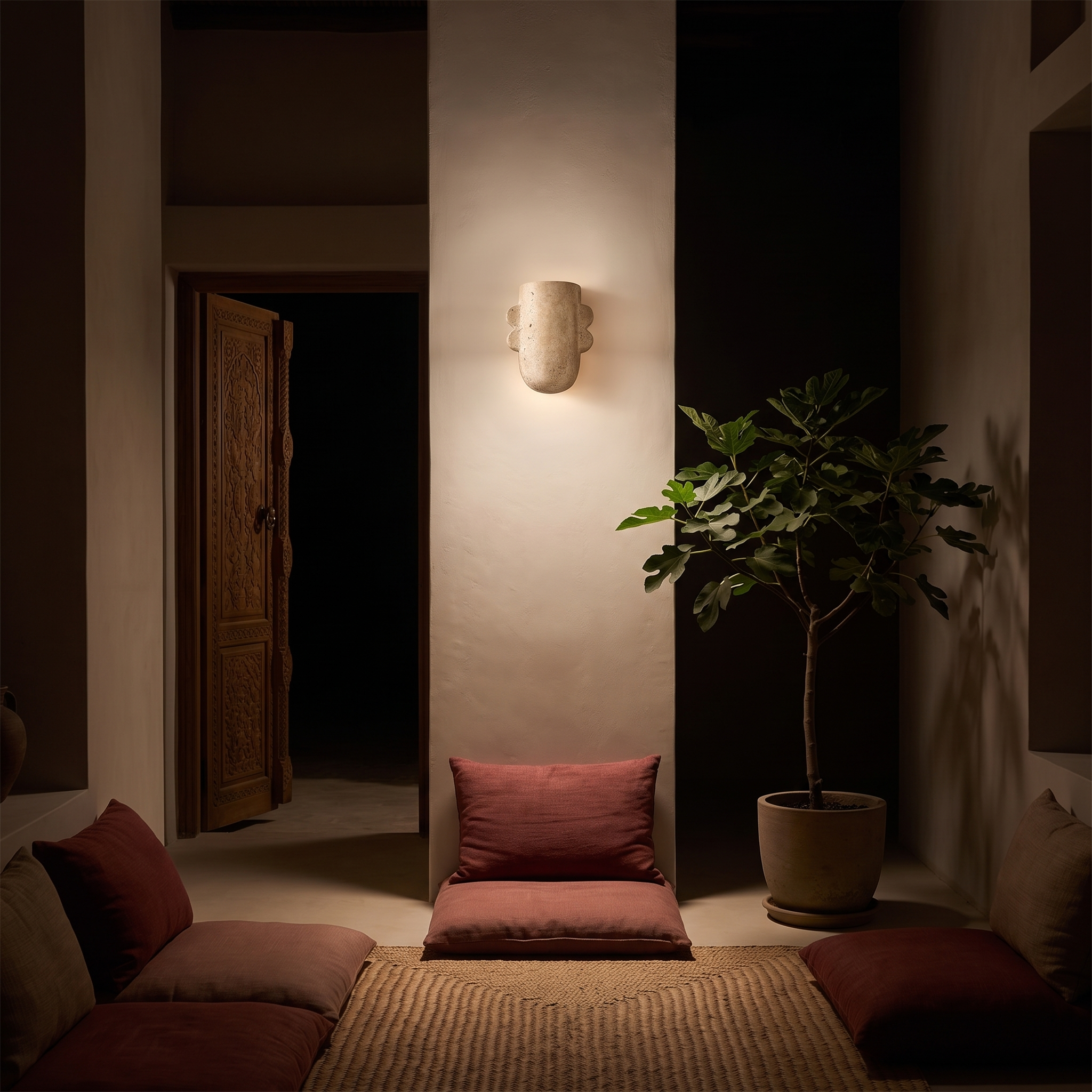 Thoosa sculptural travertine wall lamp at night