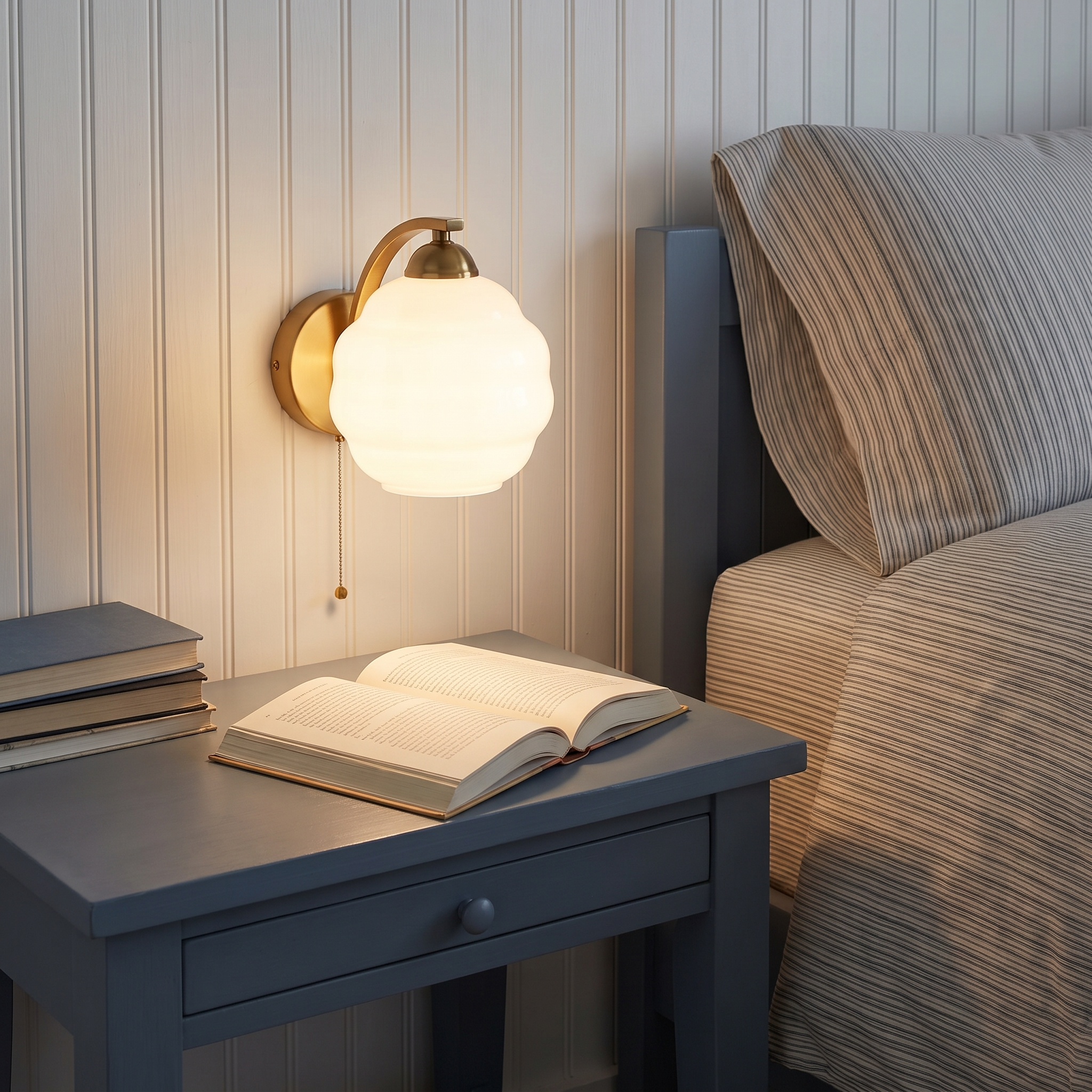 Eudore - Curved Glass Wall Sconce shown lit beside a bed in an interior