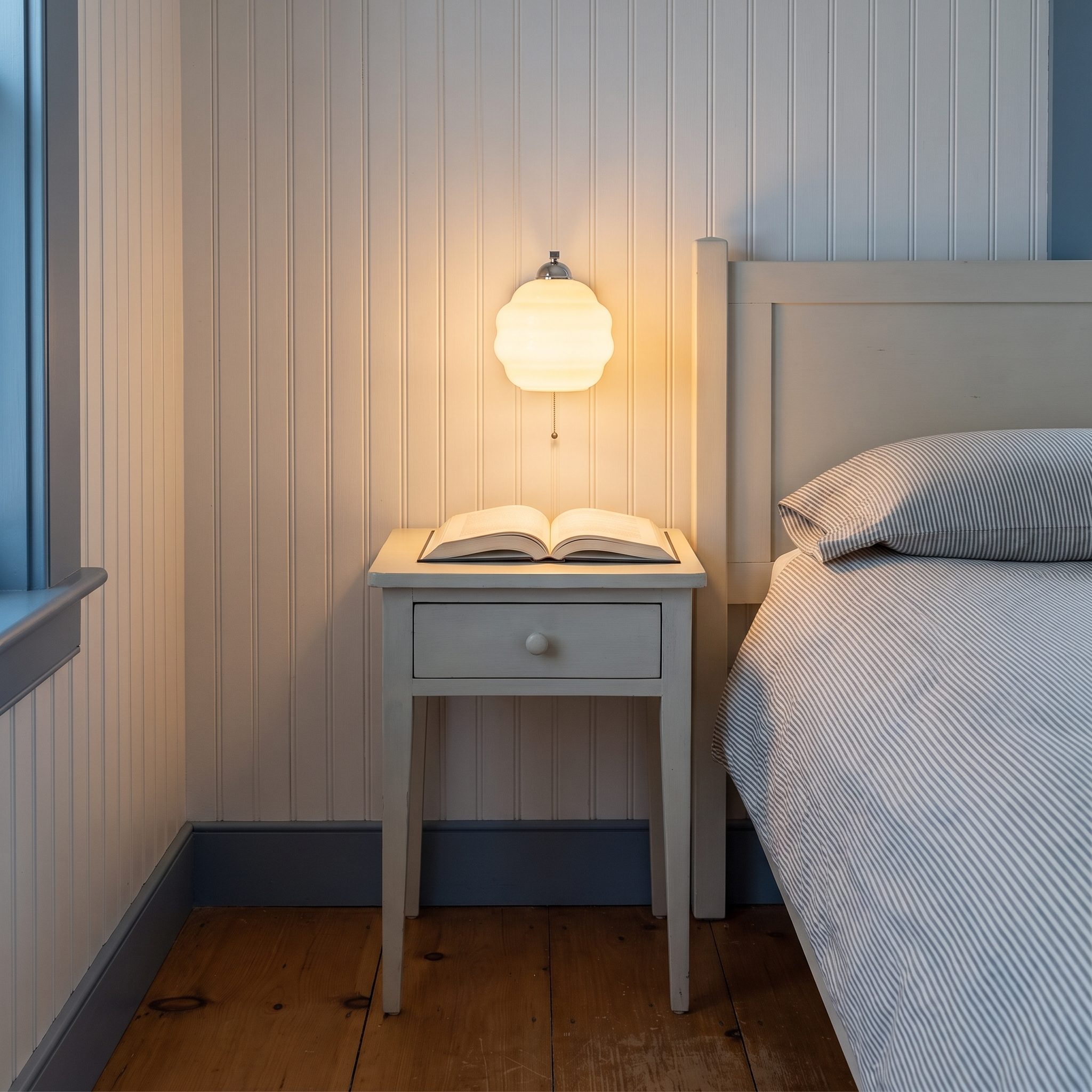Eudore - Curved Glass Wall Sconce in Chrome and Beige shown lit in an interior
