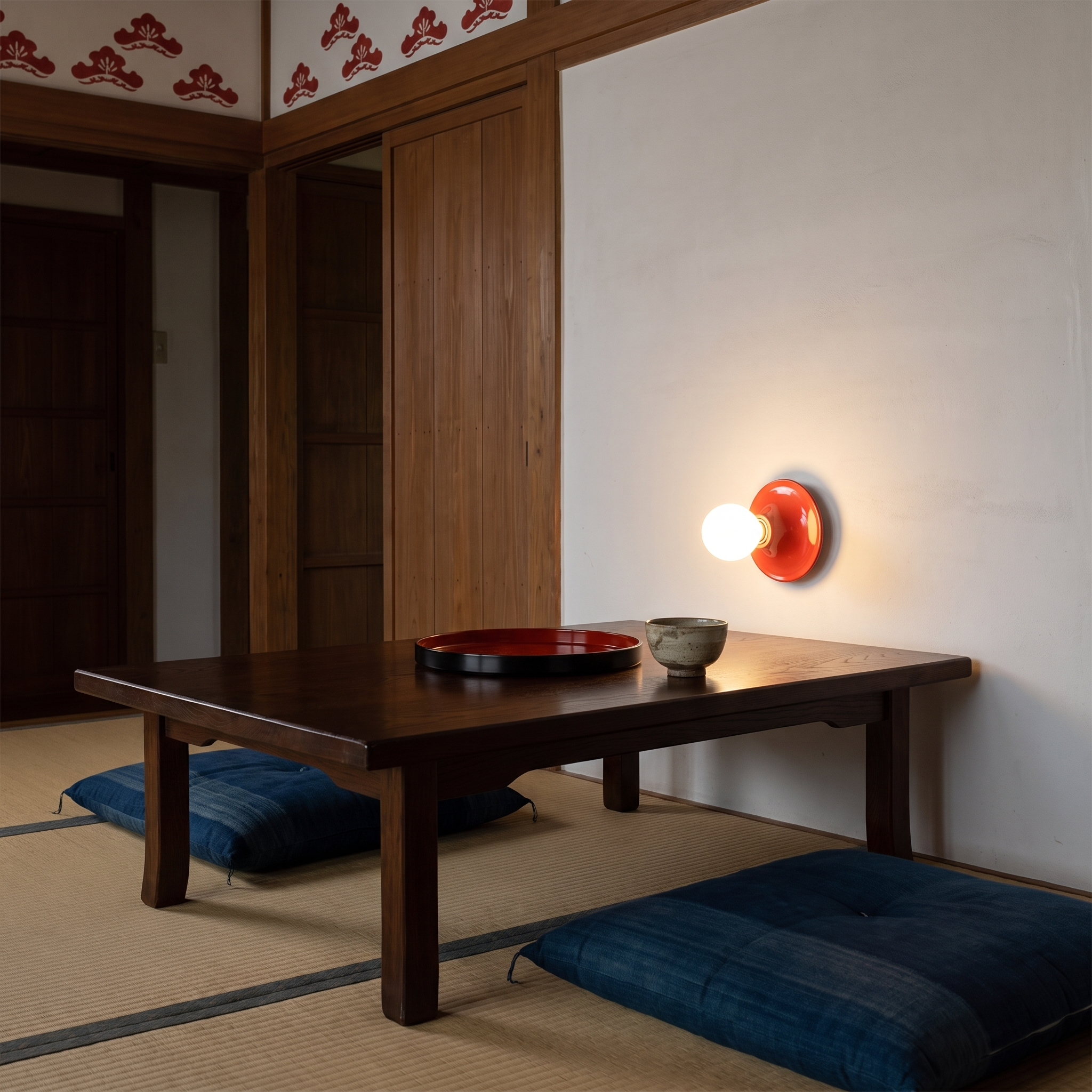 Apseudes - Trumpet Base Wall Sconce in Red with white glass bulb shown lit in an interior