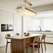 Hermione glass rod chandelier in a bright marble kitchen dining area