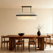 Hermione glass rod chandelier above a wooden table in a minimalist beige room
